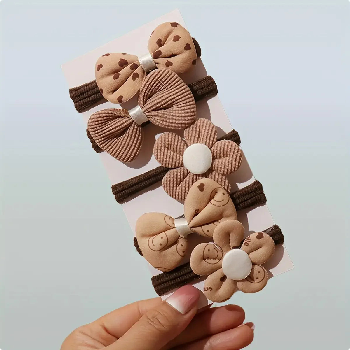 Set of 10 sporty hair accessories for girls with a floral design and a bow tie, in light beige color.